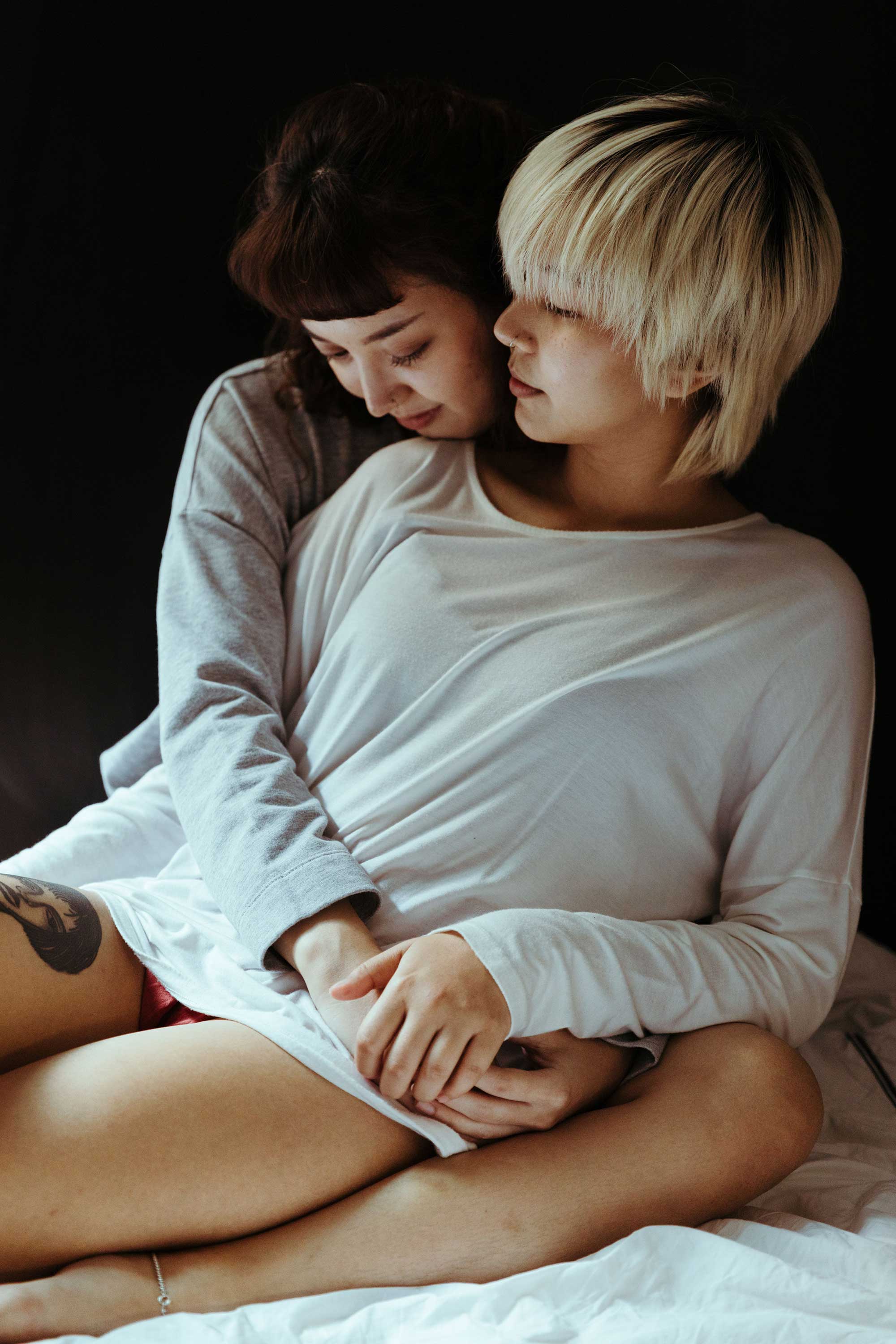 Two people sharing a tender, intimate embrace while seated closely together